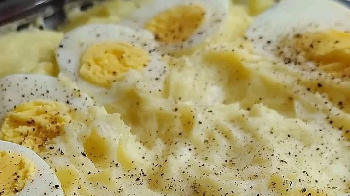 Plat of Southern potato salad with chopped eggs, pickles, and a creamy mustard-mayo dressing.